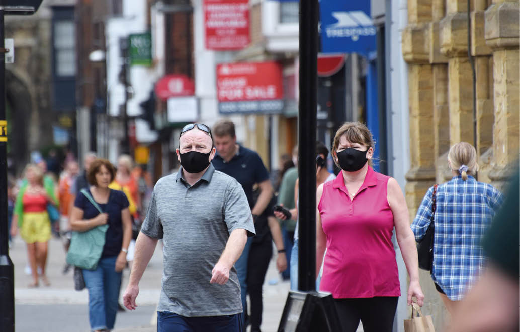 Wiltshire, UK  July 26 2020  An overweight couple wear face masks in a town centre while out shopping on the first weekend that wearing face coverings in shops becomes law in England  