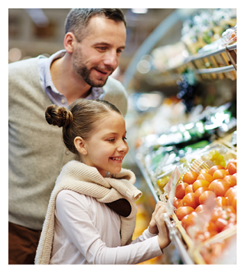 Portrait of cute little girl with dad leaning over vegetable counter choosing fresh ripe tomatoes and other vegetables in supermarket