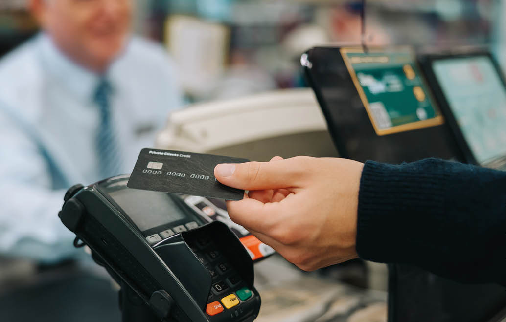 Close-up of a unrecognisable person using credit card to pay at grocery store  Customer making a payment for the purchase using his nfc card at supermarket 