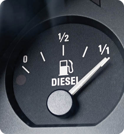 Close-up shot of a diesel fuel gauge in a car. The meter pointer showing that the tank is completely full. Glare of light present on the gauge glass cover. Copy space
