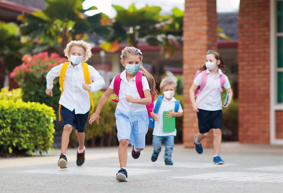 School child wearing face mask during corona virus and flu outbreak  Boy and girl going back to school after covid-19 quarantine and lockdown  Group of kids in masks for coronavirus prevention  