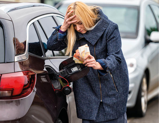 worried woman with euro cash at the car, put money to car tank, the concept of rising fuel prices