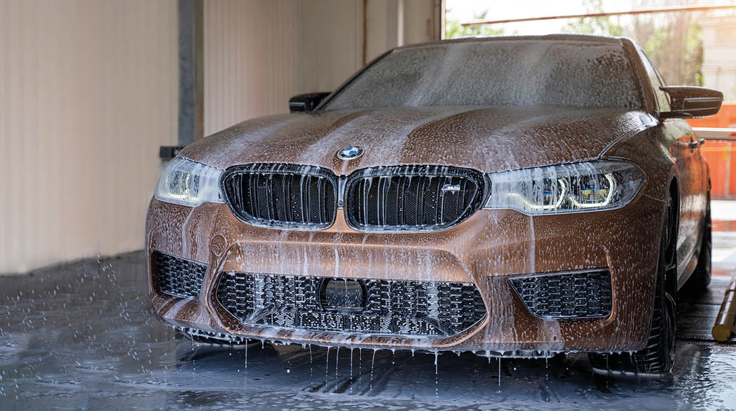 Astrakhan, Russia 1 June 2021: the BMW M5 competition sports car in an exclusive color is washed on an automatic car wash with foam