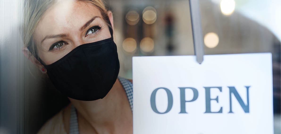 Coffee shop woman owner with face mask, open after lockdown quarantine.