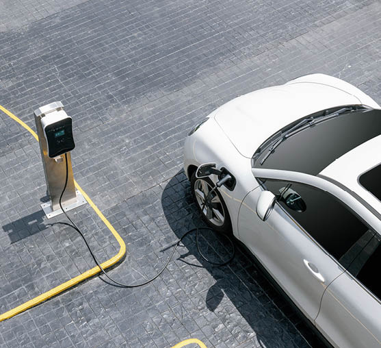 Aerial top view image of progressive green energy-powered charging station, electric vehicle at public car park with EV car concept for alternative transportation and energy infrastructure.