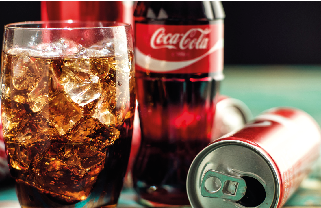 MINSK, BELARUS-AUGUST 26, 2016: Glass of Coca-Cola with ice, can and bottle of Coca-Cola on wooden background  Coca-Cola is a carbonated soft drink sold in stores, throughout the world 