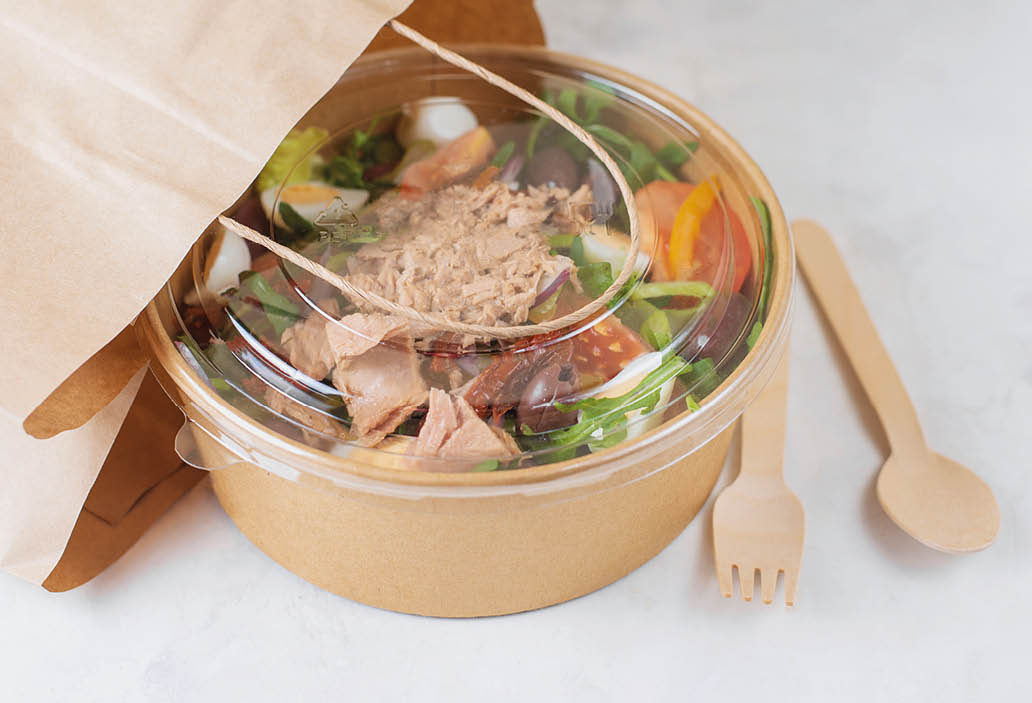 Fish diet salad with tuna, tomatoes, arugula on light background  Healthy vegetarian lunch  Concept eco restaurant delivery, environment protection  Take away food in brown paper craft plate  