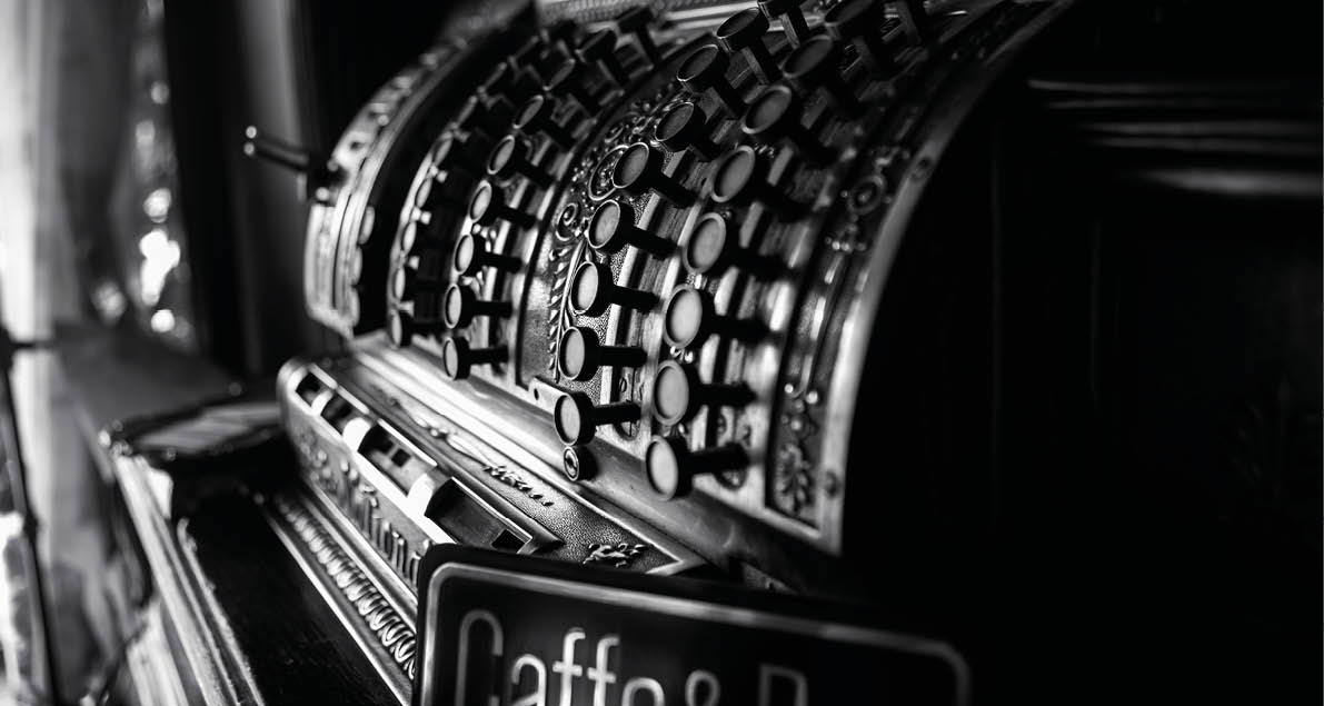 Black and white image of an old 19th century cash register. Selective focus on cashier buttons.