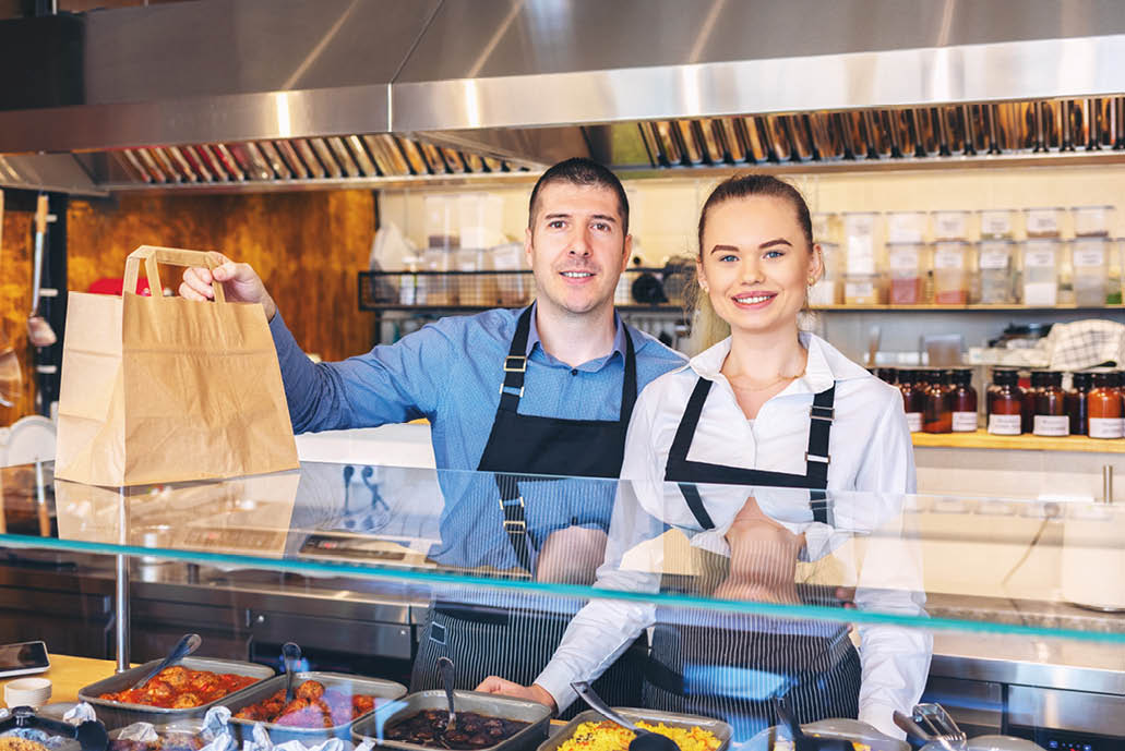 Small business and to go service concept due to isolation emergency with young restaurant owners working hard for take away food orders and deliveries to clients staying at home in quarantine