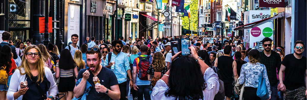 Tourists and locals crowd the street in Dublin Ireland during the summer holidays. June of 2018