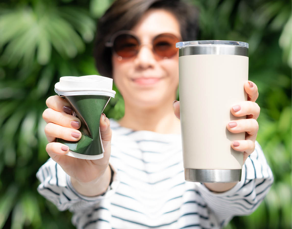 A stylish beautiful woman holding takeaway coffee cup in both hands, one is a single use paper cup with plastic lid the other one is a reusable stainless tumbler  Say no to plastic, No straw, 0 waste 