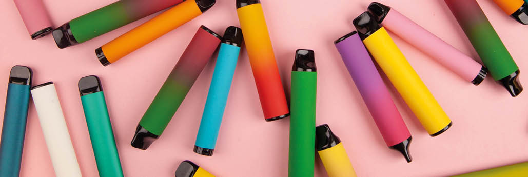 Disposable e-cigarettes with different flavors in pink. The concept of modern smoking, vaping and nicotine.