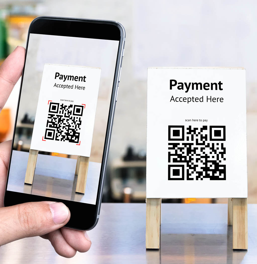 Qr code payment , online shopping , cashless technology concept. Coffee shop accepted digital pay without money , plastic tag on table and hand using mobile phone application to scan qr code.