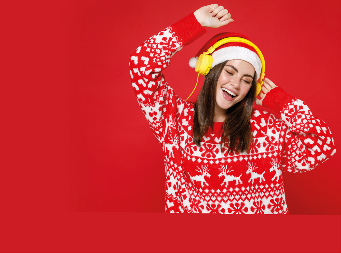 Funny young Santa woman 20s in sweater Christmas hat listening music with headphones dancing rising hands isolated on red background studio portrait. Happy New Year celebration merry holiday concept
