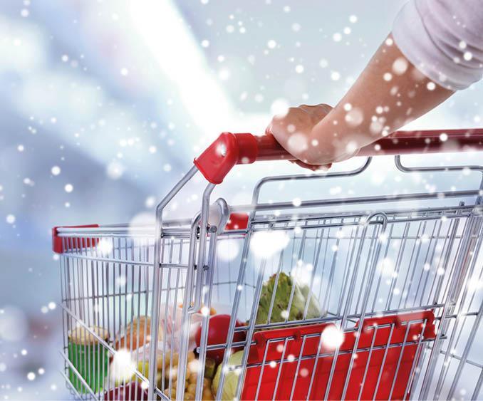 Young woman with shopping cart in store over snow effect