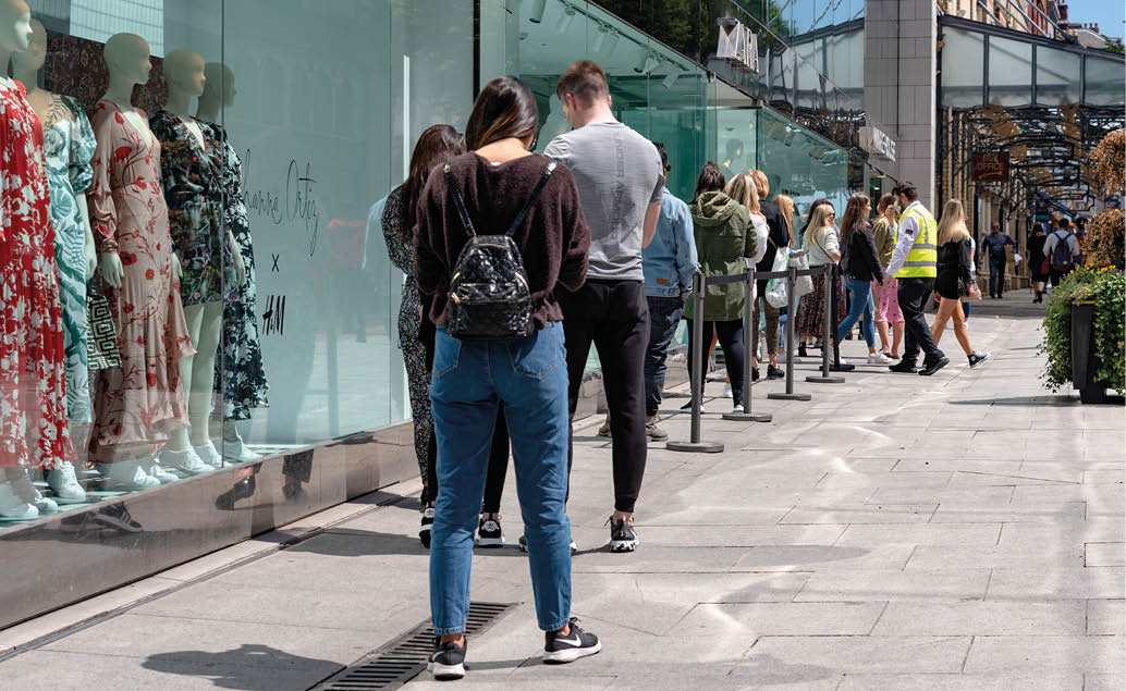 Dublin, Ireland - June 08 2020: Long line of people queueing outside of a clothing shop on King Street  mantaining social distance during coronavirus COVID-19 lockdown