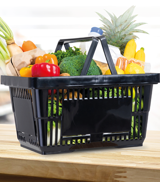 Shopping basket full of groceries on wood counter in supermarket background