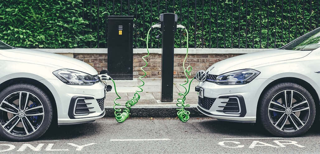 London UK-30 07 18: two white Volkswagen Golf GTE cars charging at a charging point on a street in London  The Golf GTE is a plug-in hybrid version of the Golf hatchback