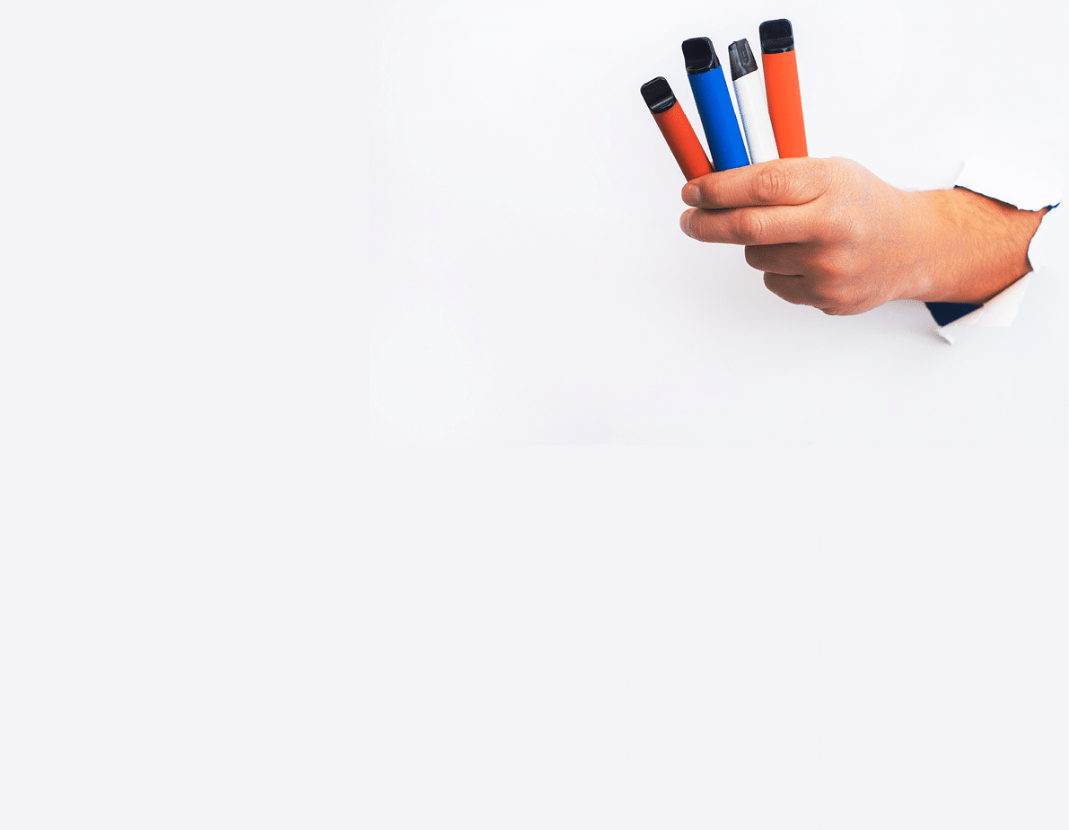 Set of Disposable electronic cigarettes in hand closeup on a white background with shadows. The concept of modern smoking, vaping and nicotine. Copy space