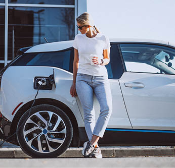 Woman charging electro car at the electric gas station