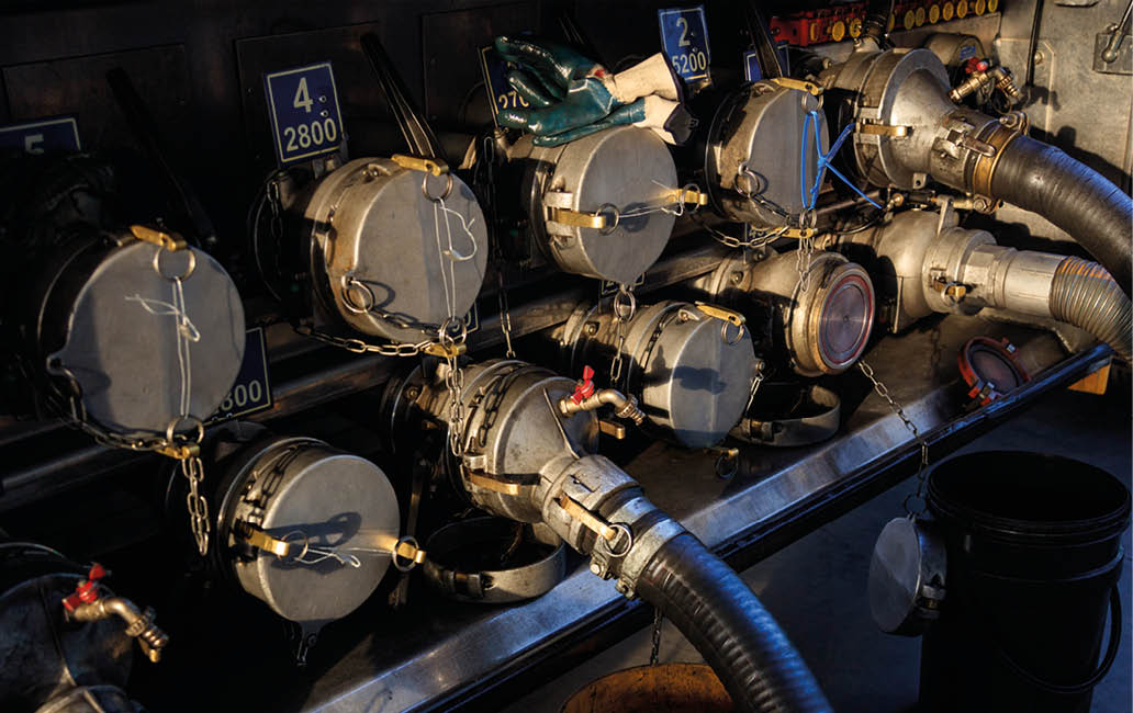 Tanker truck filling up storage tank at the fuel station