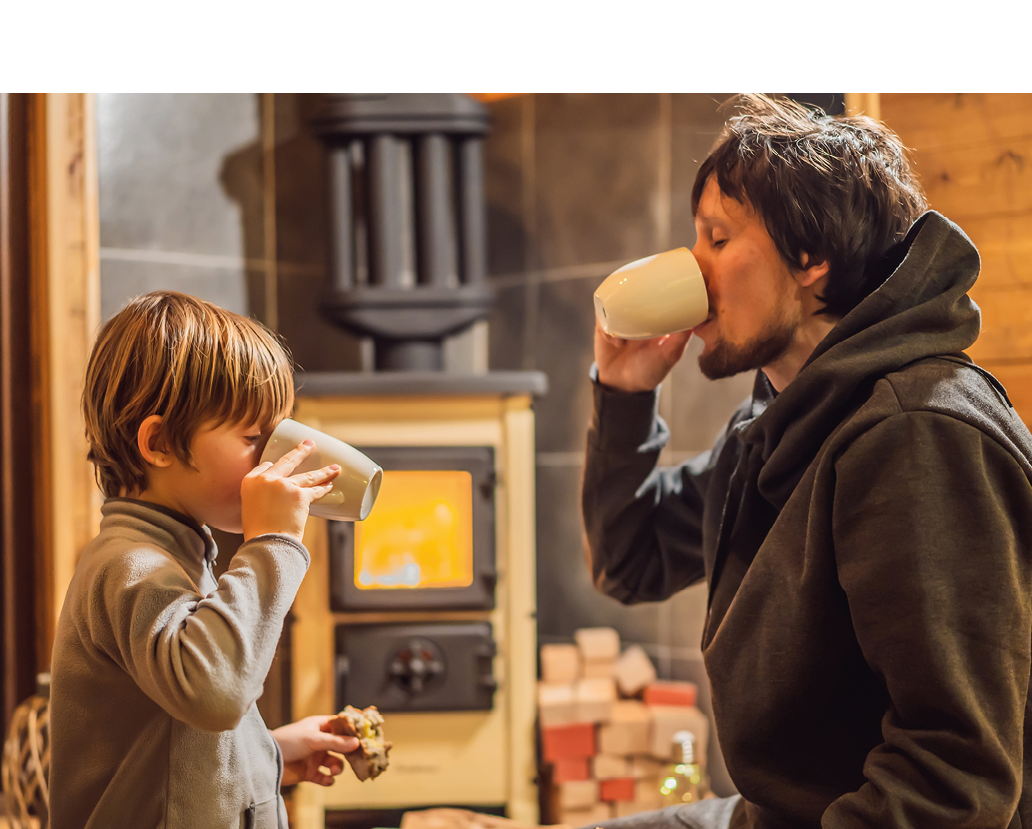 Dad and son spend time by the fireplace in Glamping. Rest in the mountains in Glamping. Cozy fireplace in a mountain house