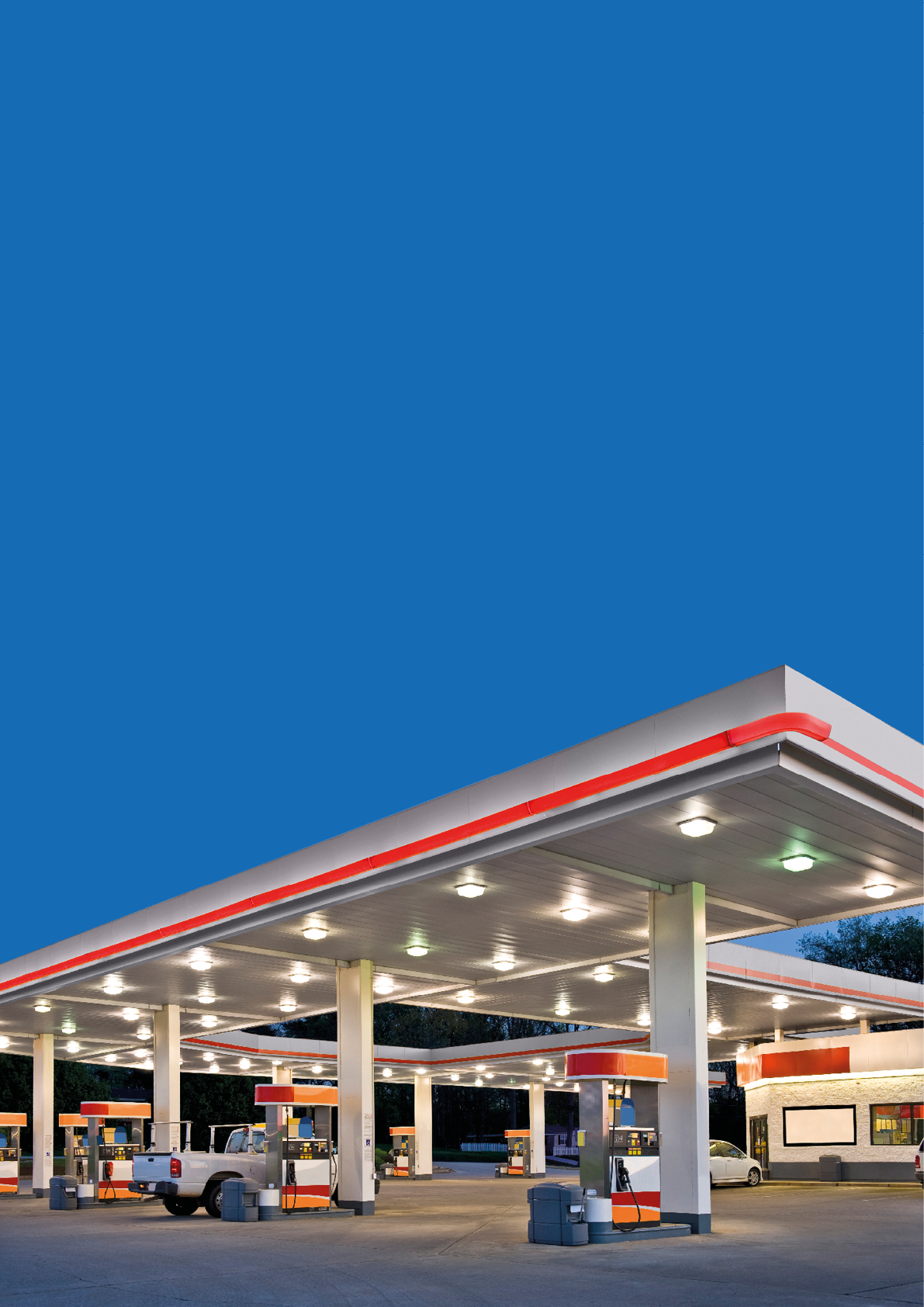 Horizontal shot of a retail gasoline station and convenience store at dusk.