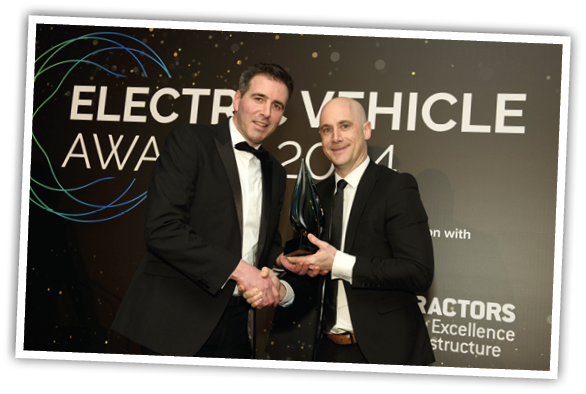 Two men shaking hands with a trophy Description automatically generated