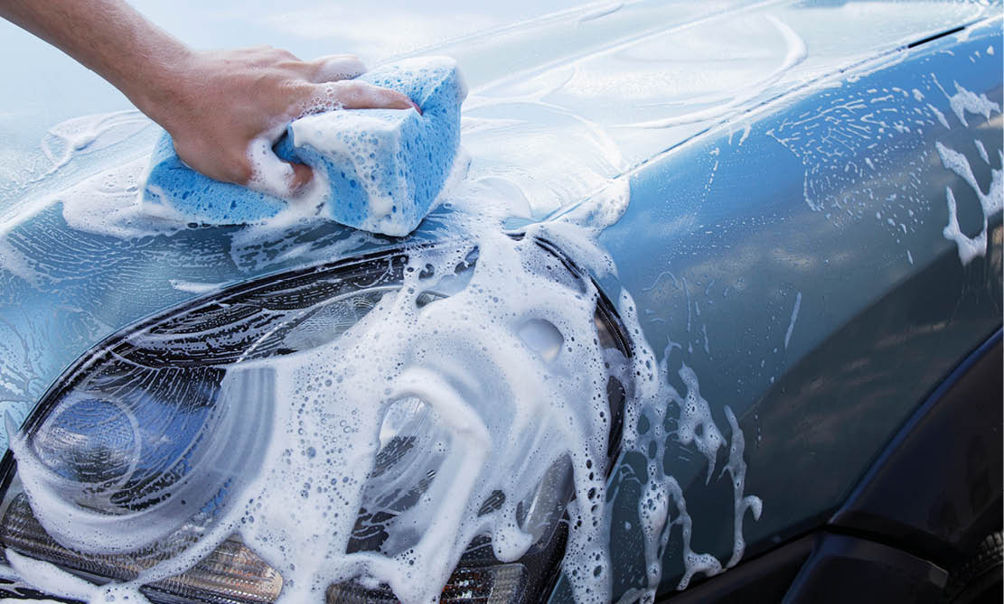 the turquoise car is washing in soap suds