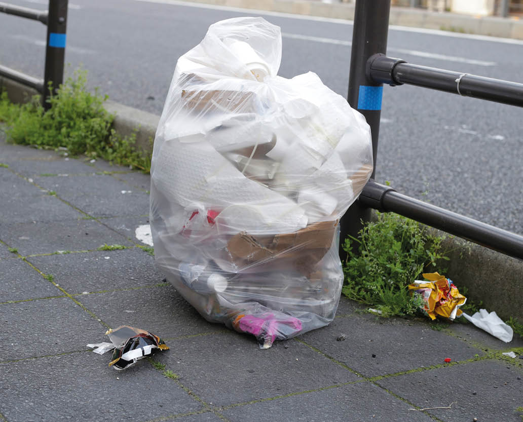 Garbage bag lay on sidewalk.