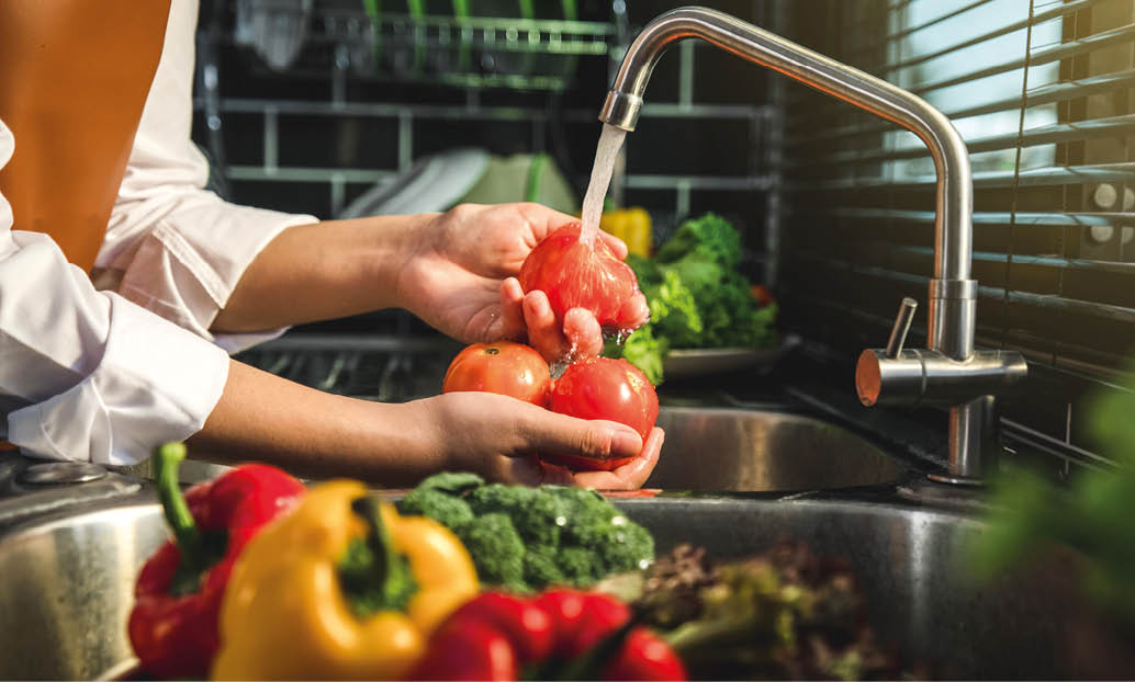 Hand of maid washing tomato fresh vegetables preparation healthy food in kitchen
