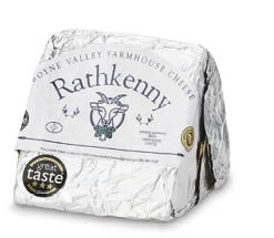A wrapped block of Rathkenny farmhouse cheese with a white label featuring a goat illustration and award stickers. Description generated by AI