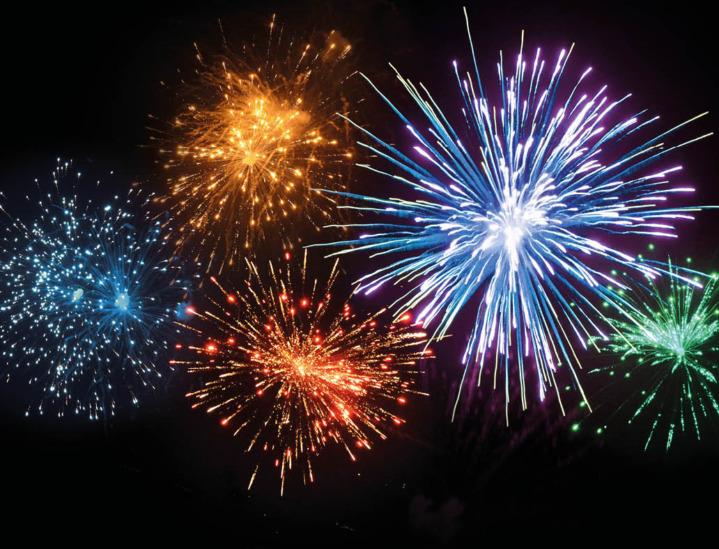 Colorful fireworks burst against a dark night sky with blue, orange, red, purple, and green sparks radiating outward. Description generated by AI