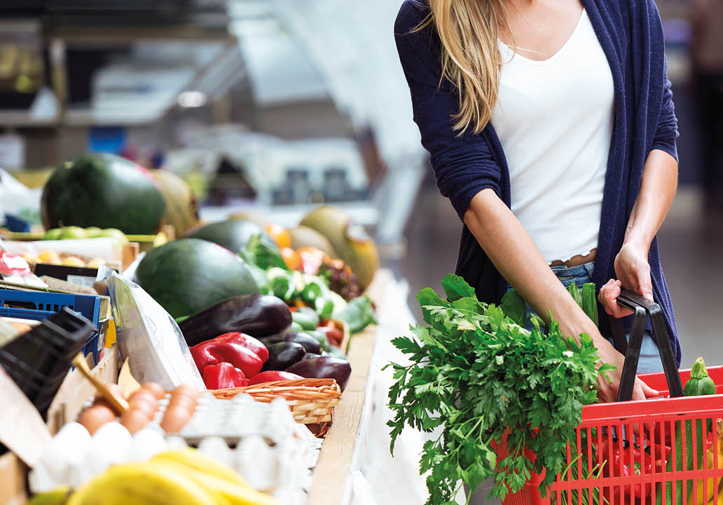Shot of beautiful young woman buying fresh vegetables in the market.