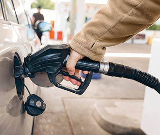 man filling fuel tank of car with diesel at petrol station 
