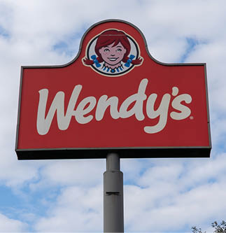 Houston, TX, USA - March 4, 2022: A Wendy’s restaurant pole sign with blue sky in background. The Wendy's Company is an American holding company for the major fast food chain Wendy's. 