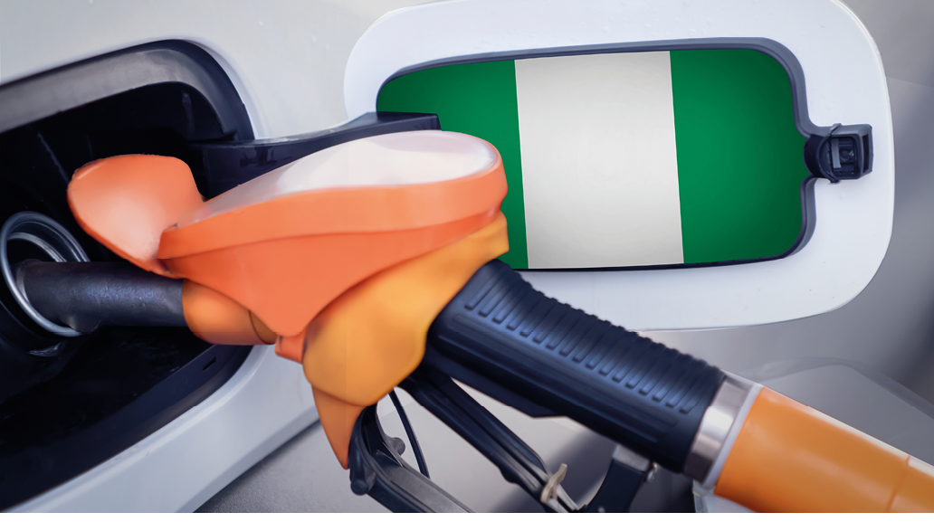 The Nigeria flag on the lid of the gas tank of a car at a gas station in close-up. High or low gasoline prices at Nigerian gas stations. In Nigeria, gasoline prices are rising due to a shortage of
