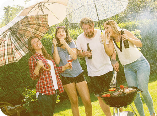 Young people having fun at picnic despite the rain at sunset