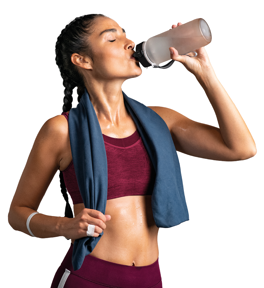 Fitness woman drinking water standing on gray background with copy space. Portrait of sweaty latin woman take a break after intense workout. Mid adult lady drink from water bottle after gym workout. 