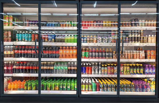 PENANG, MALAYSIA - 12 OCT 2023: A large fridge in Giant grocery store in Penang showcases a wide range of beverage choices displayed on its shelves.