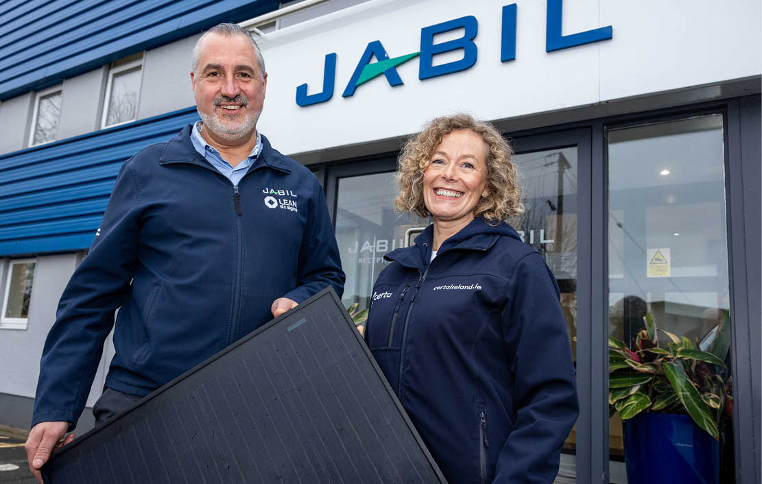 A man and woman are standing in front of a building, holding a solar panel. AI generated content