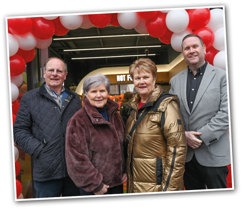 Three people pose for a picture in front of a red and white banner. AI generated content