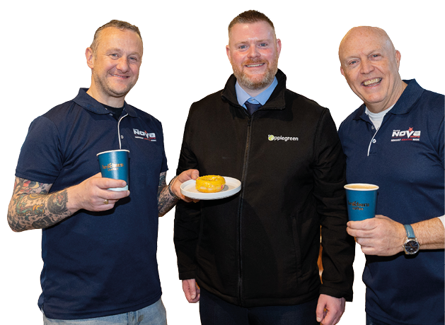 Three men in blue shirts are standing together, smiling and holding food. One of them is wearing a black jacket. They are all holding cups, possibly containing coffee. AI generated content