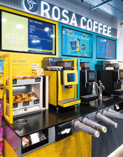 A coffee shop with a yellow and black coffee machine. Description generated by AI