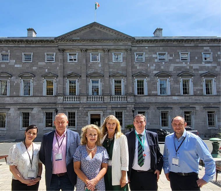 A group of people standing in front of a building. Description generated by AI