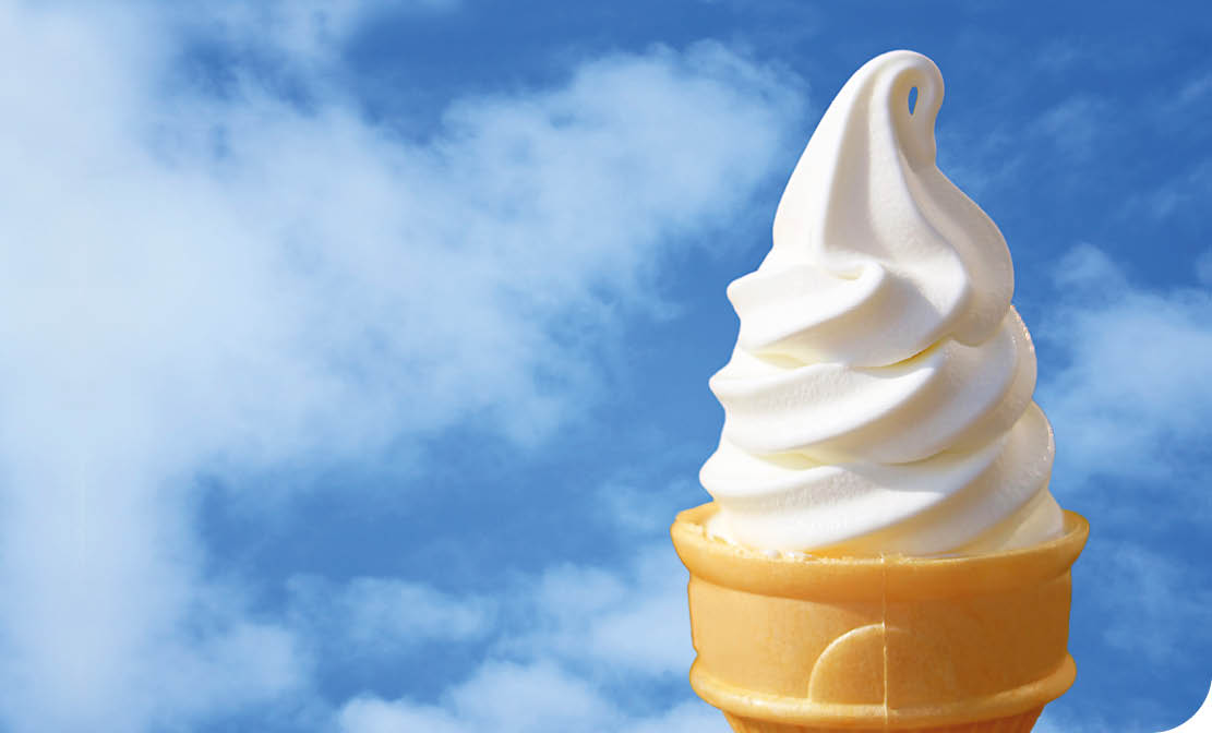 A yellow ice cream cone with white swirls. Description generated by AI