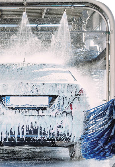A white car is being washed in a car wash. Description generated by AI
