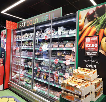 A refrigerated display case in a grocery store with a sign that says “Eat Colourful". AI generated content