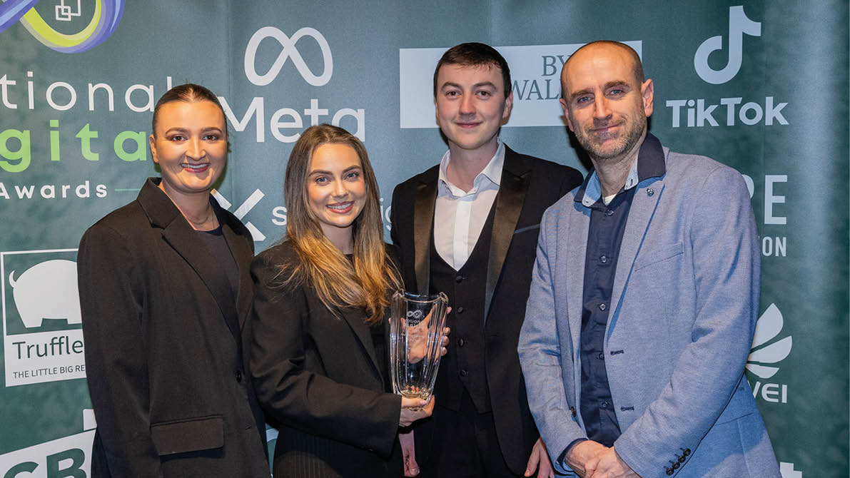 A group of people are standing in front of a banner. Description generated by AI