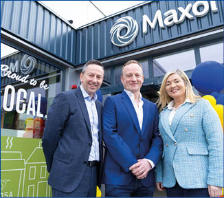 Three people standing in front of a Maxol sign. Description generated by AI